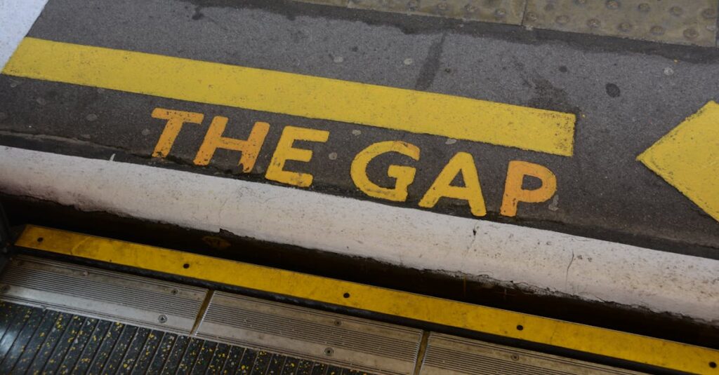 Prayer Ministries | English Close-up of 'Mind the Gap' warning sign on station platform edge, focusing on safety.